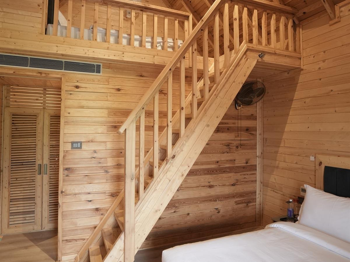 Hand-crafted wooden staircase and louvred wardrobe in the Deluxe Cottage