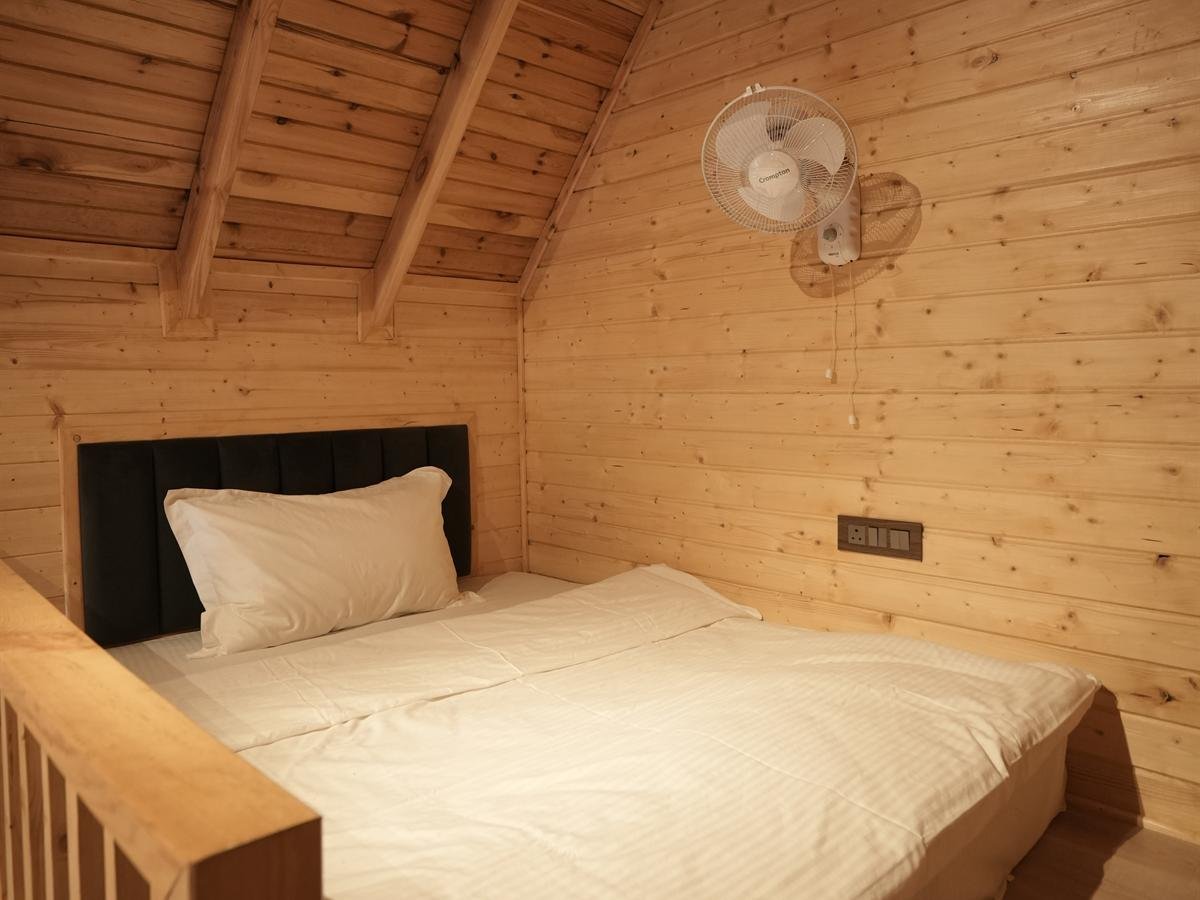 Mezzanine loft bed beneath the pitched roof of the Deluxe Cottage