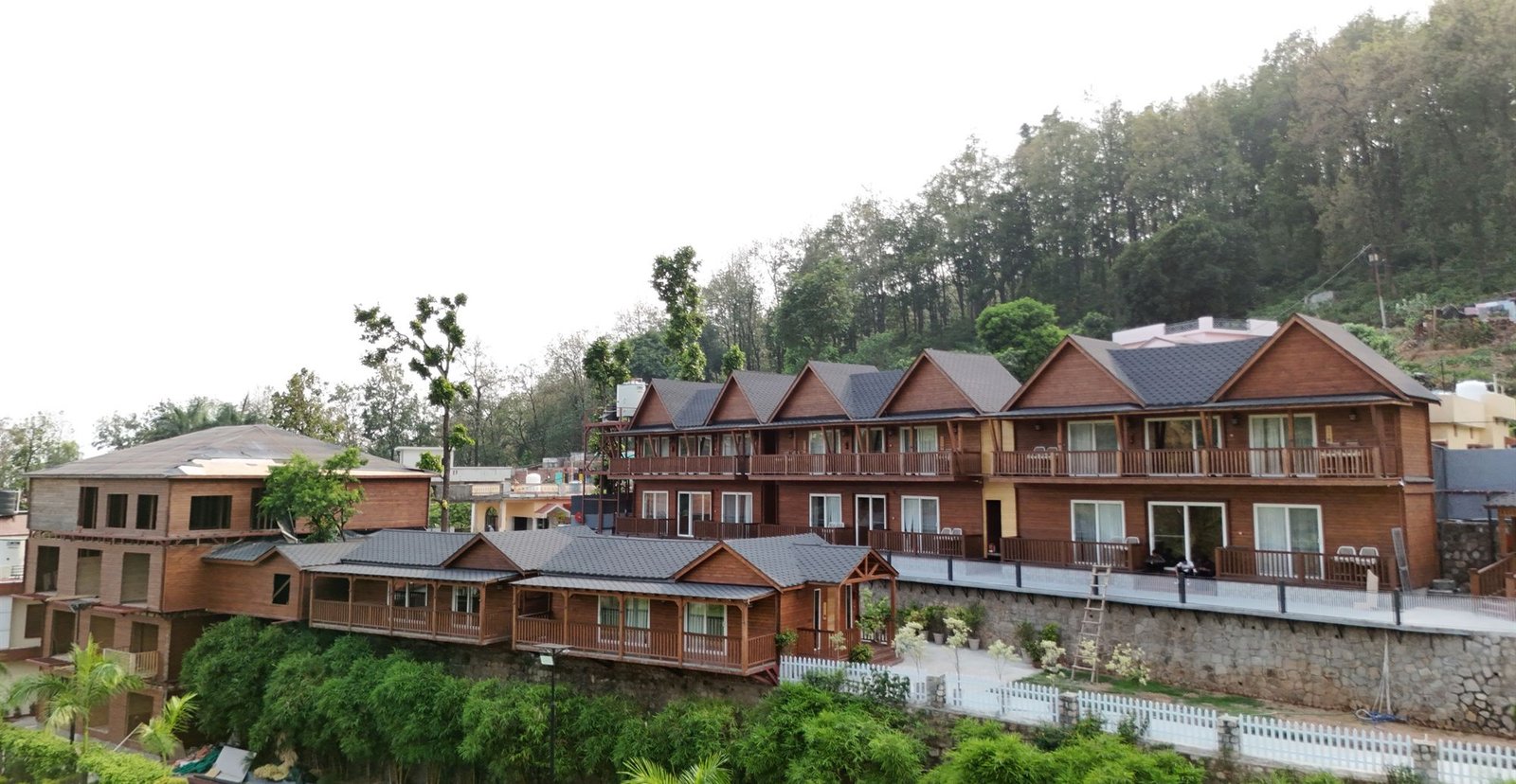 The timber cottages at JSR Inn, set against the wooded hillside