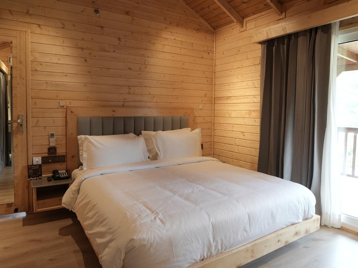 Suite Cottage bedroom beneath a vaulted timber ceiling